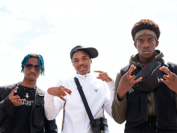 drie rappers maken handgebaren